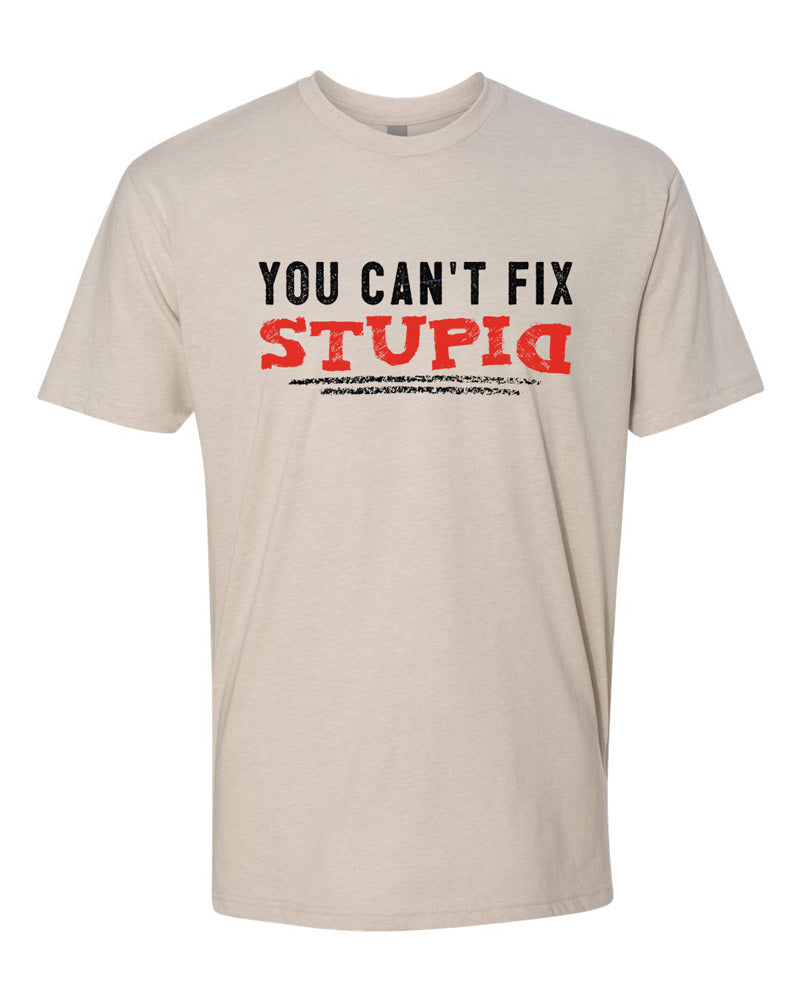 Sand-colored tee with black and red text reading "you can't fix stupid." Stupid is in red and underlined in black.