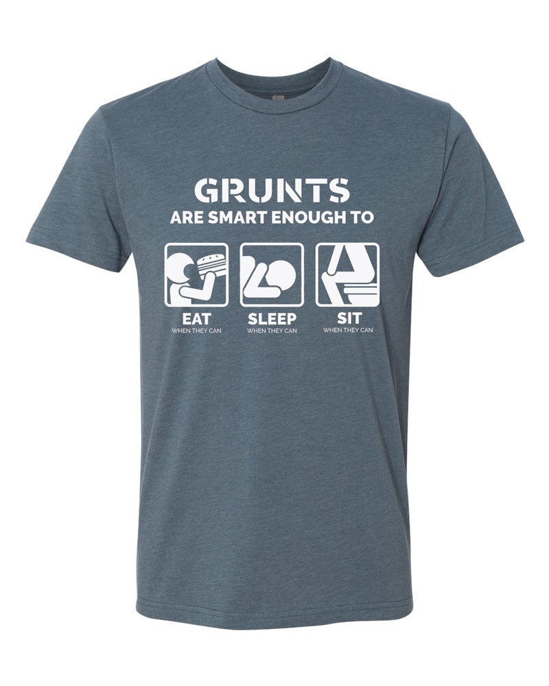 Indigo tee with white text reading "Grunts are smart enough to eat when they can, sleep when they can, sit when they can." Three simplified drawings of a person eating, sleeping, and sitting on a toilet are featured.