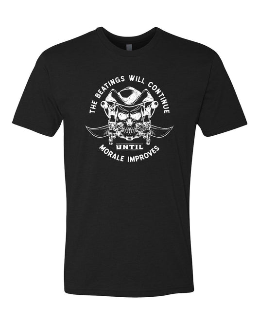 White imprint on a black tee. Text reads "beatings will continue until morale improves." Image is of a skull and crossbones. Skull is wearing a pirate hat. Bones are draped with a heavy chain. Behind everything is two crossed curved swords.